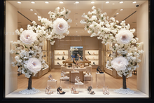 Load image into Gallery viewer, White flower trees framing women's shoe store window
